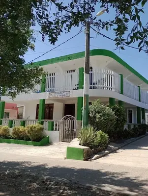 a building with a green and white at Sol y Mar in Isla Fuerte