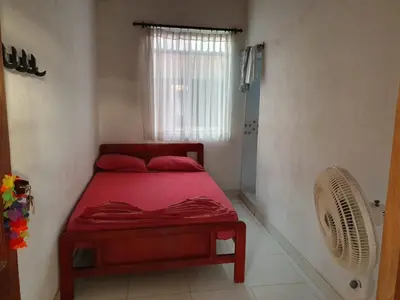 a bedroom with a red bed and a window at Sol y Mar in Isla Fuerte