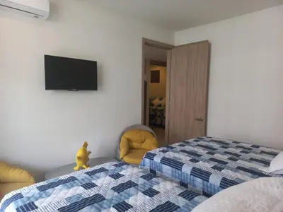 a bedroom with a bed and a flat screen tv at Apto morroszoe 217A in Cartagena de Indias
