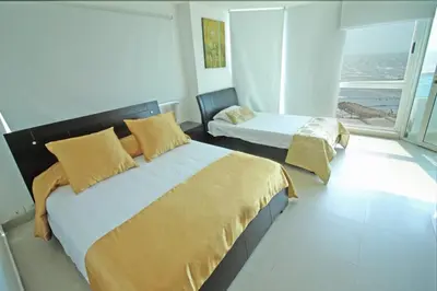 a bedroom with two beds and a large window at Apartamento torres del lago in Cartagena de Indias