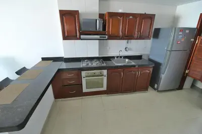 a kitchen with wooden cabinets and stainless steel appliances at Apartamento torres del lago in Cartagena de Indias
