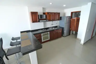 a kitchen with wooden cabinets and a counter top at Apartamento torres del lago in Cartagena de Indias