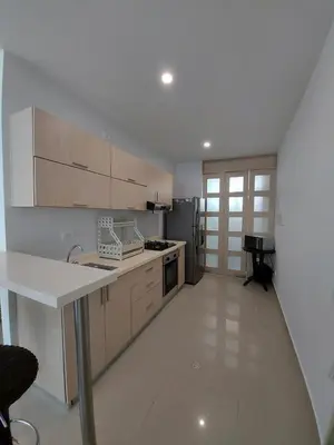 a kitchen with white counters and a white floor at Hermoso apartamento con piscina frente al mar - Primera Ensenada in Coveñas