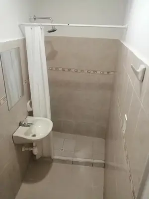 a white bathroom with a sink and a shower at HOSTEL M&H in Cartagena de Indias