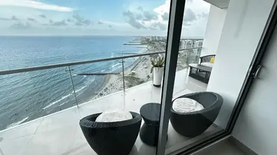 a balcony with two chairs and a view of the ocean at Front beach apartment close to the Cartagena letters in Cartagena de Indias
