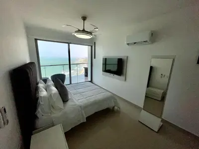 a bedroom with a bed with a view of the ocean at Front beach apartment close to the Cartagena letters in Cartagena de Indias