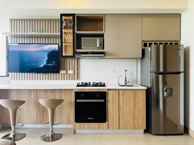 a kitchen with a stainless steel refrigerator and stools at Fantastic Loft/Beachfront+Pools in Cartagena de Indias