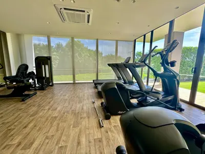 a gym with treadmills and ellipticals in a room with windows at Fantastic Loft/Beachfront+Pools in Cartagena de Indias