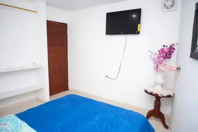 a room with a blue bed and a tv on a wall at cabaña villa Oti 1 in Ciénaga