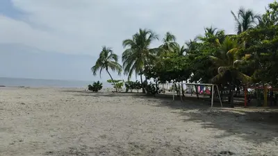 a sandy beach with palm trees and a soccer goal at cabaña villa Oti 1 in Ciénaga