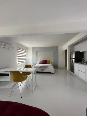 a bedroom with a bed and a table and chairs at Apartasuites Mardini in Cartagena de Indias