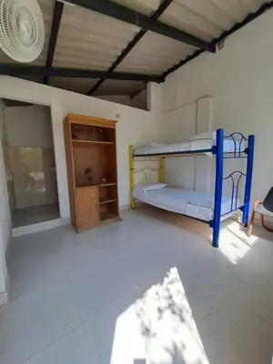 a room with two bunk beds and a cabinet at Mar Rosa Galerazamba Hostal in Galerazamba