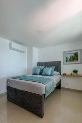 a bedroom with a bed with blue pillows at APARTAMENTO EDIFICIO MONTU in Cartagena de Indias