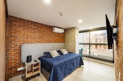 a bedroom with a bed and a brick wall at Apartamento ubicado en, LAURELES, MEDELLIN in Cartagena de Indias