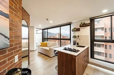 a kitchen and living room with a brick wall at Apartamento ubicado en, LAURELES, MEDELLIN in Cartagena de Indias