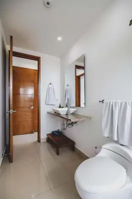 a bathroom with a toilet and a sink and a mirror at SkyMar Luxury 27 in Cartagena de Indias