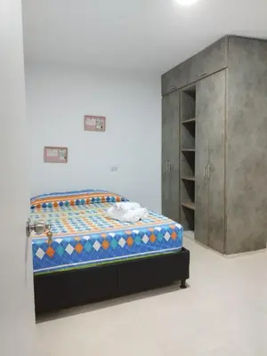 a bed and a cabinet in a room at Apartamento con ubicación estratégica in Cartagena de Indias