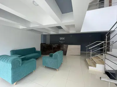 a lobby with two blue chairs and a staircase at Hotel Mariscales Sincelejo in Sincelejo