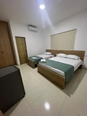 a bedroom with two beds and a flat screen tv at Hotel Mariscales Sincelejo in Sincelejo