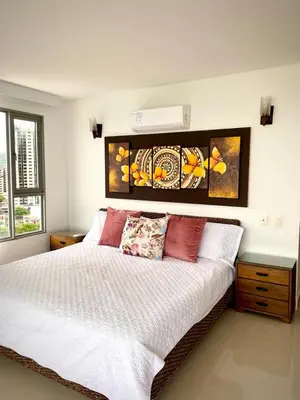 a bedroom with a large white bed with red pillows at Apartamento con espectacular vista al oceano in Cartagena de Indias