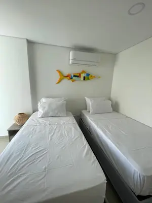 a bedroom with two beds and a fish on the wall at Infinity Blue - Playa Dormida in Santa Marta