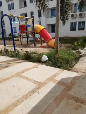 a playground in front of a building with a slide at 