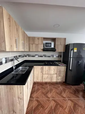 a kitchen with wooden cabinets and a black refrigerator at 