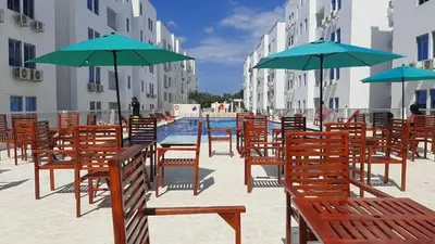 a group of chairs and umbrellas next to a pool at 