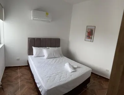 a small bedroom with a bed with white sheets and pillows at 