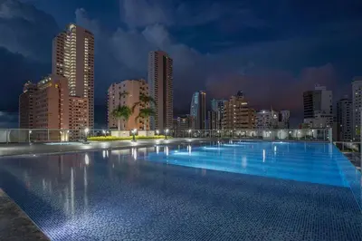 a large swimming pool in a city at night at Great apartment in Bocagrande with sunset & beach view in Cartagena de Indias