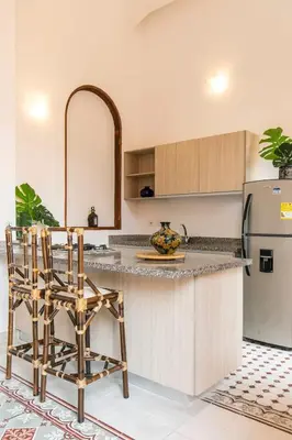 a kitchen with a counter with chairs and a refrigerator at 2CM-J1 APARTAMENTO DE 2 ALCOBAS CON VISTA Y PISCINA EN GETSEMANI in Cartagena de Indias