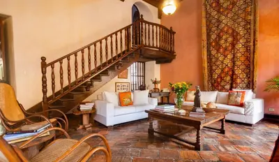 a living room with a staircase and white furniture at 4CB-1 CASA COLONIAL DE 4 HABITACIONES EN EL CENTRO HISTORICO DE CARTAGENA in Cartagena de Indias