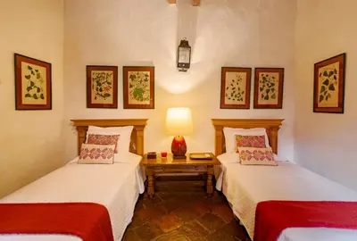 a room with two beds and a table with a lamp at 4CB-1 CASA COLONIAL DE 4 HABITACIONES EN EL CENTRO HISTORICO DE CARTAGENA in Cartagena de Indias