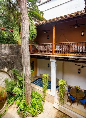 a house with a balcony and a table and a tree at 4CB-1 CASA COLONIAL DE 4 HABITACIONES EN EL CENTRO HISTORICO DE CARTAGENA in Cartagena de Indias