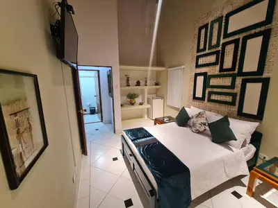 a bedroom with a bed in a room with pictures on the wall at Casa Blanca del Mar in Santa Marta