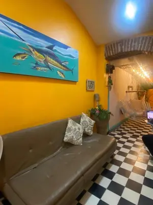 a living room with a couch and a painting on the wall at 4CR-1M CASA DE 4 HABITACIONES EN EL CENTRO HISTORICO, GETSEMANI in Cartagena de Indias