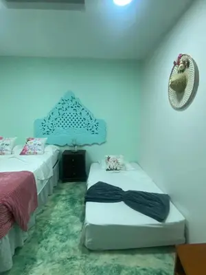 a bedroom with two beds and a blue wall at 4CR-1M CASA DE 4 HABITACIONES EN EL CENTRO HISTORICO, GETSEMANI in Cartagena de Indias