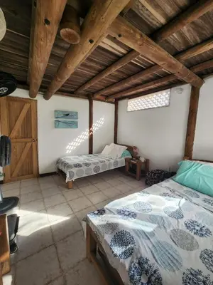 a bedroom with two beds and a wooden ceiling at Cabana Ferrer in Notecebes
