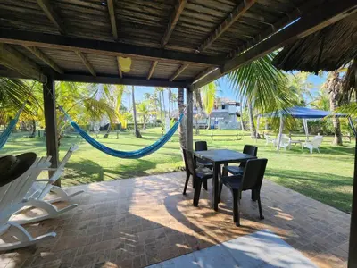 a patio with a table and chairs and a hammock at Cabana Ferrer in Notecebes