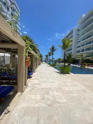 a resort walkway next to a pool with palm trees and buildings at Comodo Apartamento en morros epic! in Cartagena de Indias