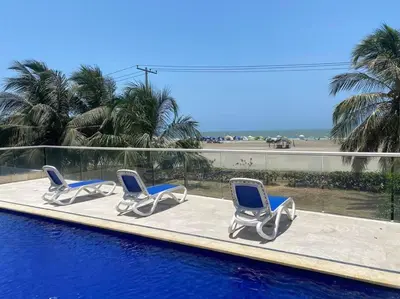 three lounge chairs sitting on a swimming pool at Comodo Apartamento en morros epic! in Cartagena de Indias
