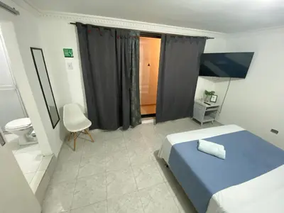 a bedroom with a blue bed and a toilet at Habitación cerca al aeropuerto 2 in Cartagena de Indias