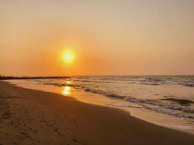 a sunset on a beach with the ocean at Tranquilo Apartamento Central Cerca a la Playa Puerto Colombia in Puerto Colombia