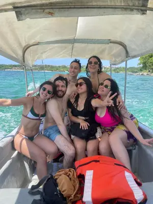 a group of people sitting on a boat in the water at Freedom Beach Club in Baru