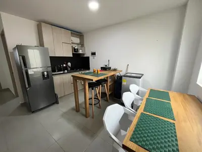 a kitchen with a table and a refrigerator at Apto 1er piso frente a la playa y con piscina in San Bernardo del Viento