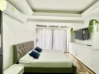 a bedroom with a bed and a tv on a wall at Cartagena apto estudio piso 12 frente a la playa in Cartagena de Indias