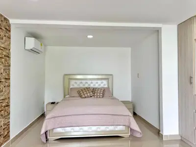 a bedroom with a bed in a white room at HELENE HOUSE in Sincelejo