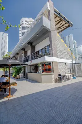 a building with a table and an umbrella in front of it at Mini departamento a una cuadra de la playa y de la bahia de Bocagrande in Cartagena de Indias