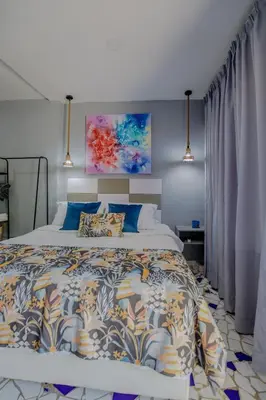 a bedroom with a large bed with a colorful bedspread at Mini departamento a una cuadra de la playa y de la bahia de Bocagrande in Cartagena de Indias