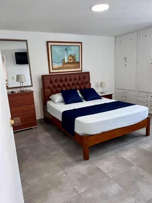 a bedroom with a large bed with blue pillows at El Laguito, Edificio El Conquistador in Cartagena de Indias